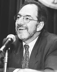 Claudio Loser speaking at a microphone, black-and-white photograph