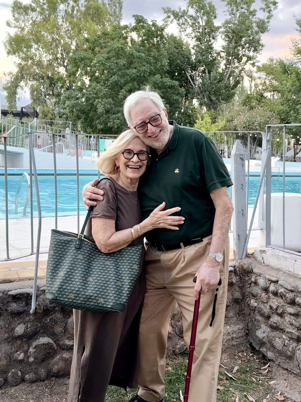 Claudio smiling with his arm around a loved one